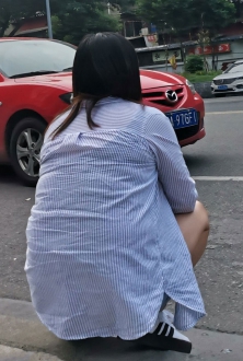 街拍蹲地上打电话丰满的女人